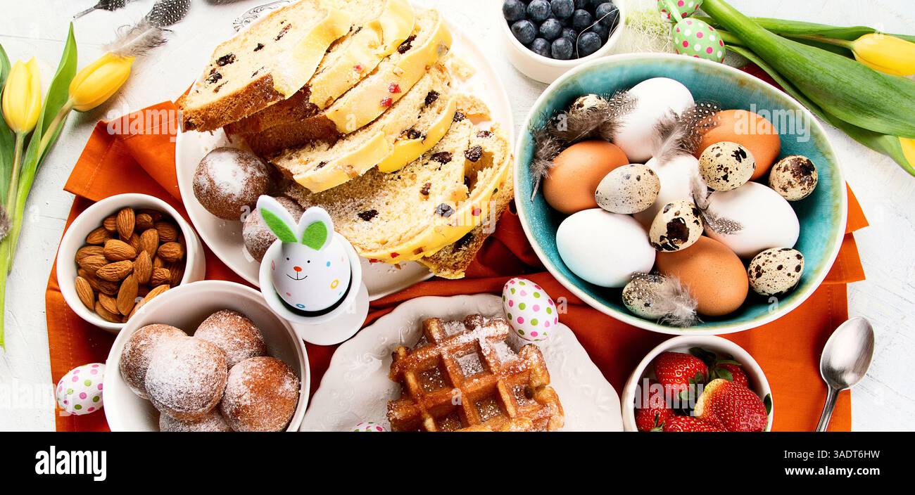 Festive Easter table setting. Natural colorful eggs and spring flowers rustic composition. Top view. Stock Photo
