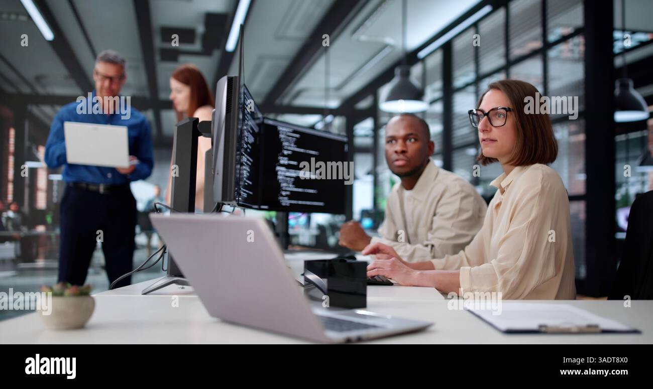 Young African American Woman Coding Software On Computer In Office. Diverse Group Stock Photo
