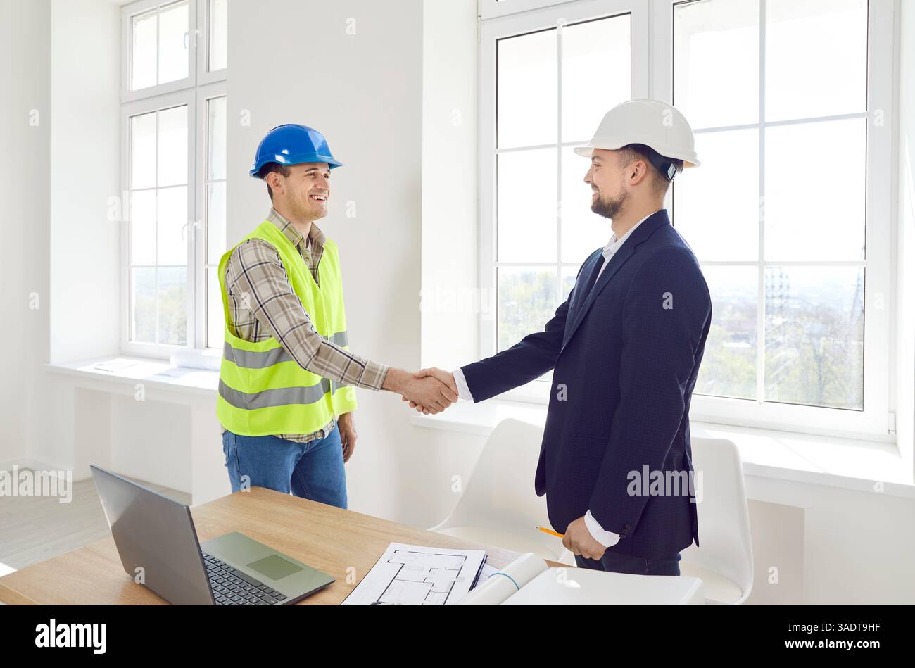 Worker Shaking Hands With Client To Confirm Construction Project Stock Photo