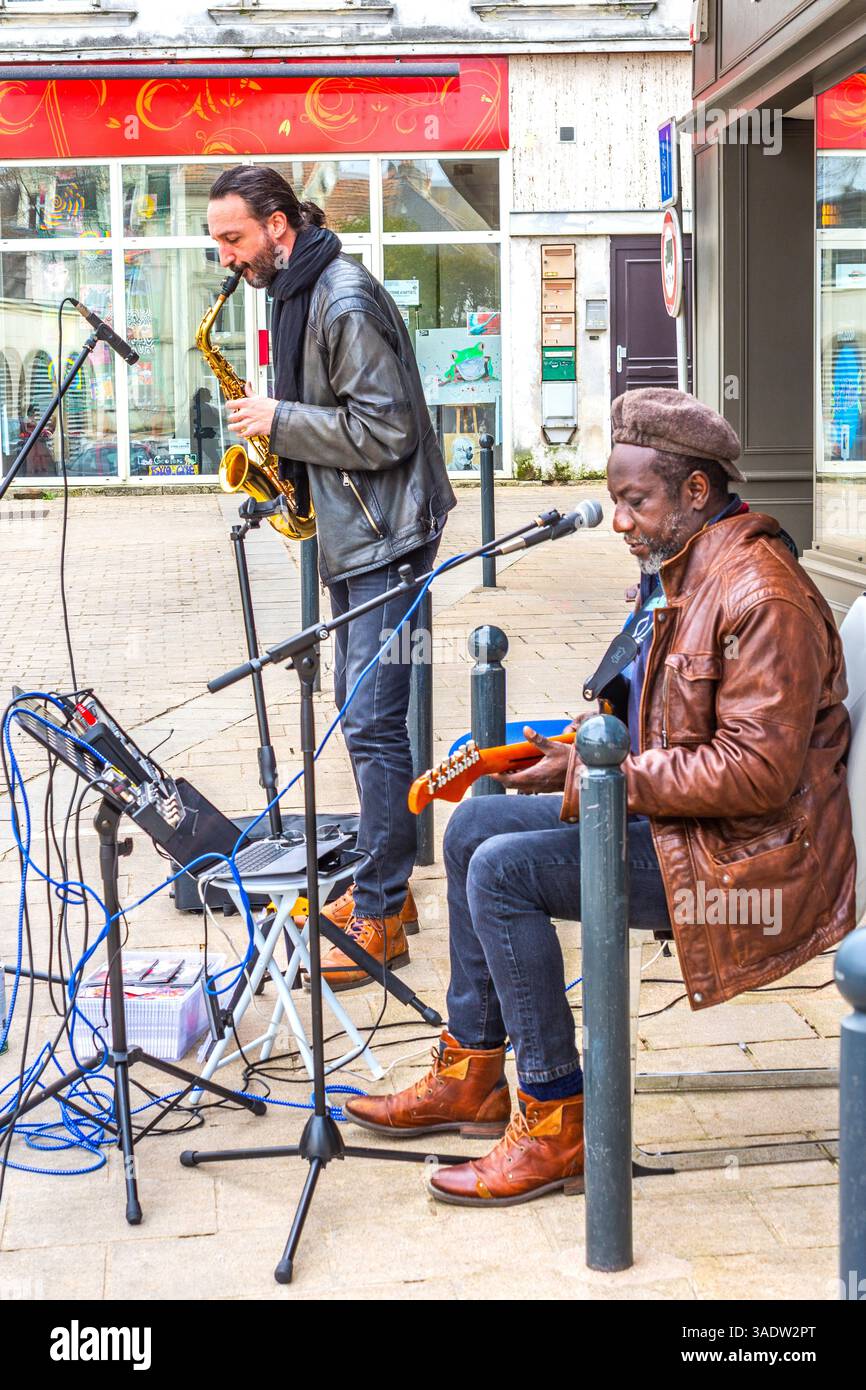 Michel Aubenas on guitar with accompanying sax player in Rock and Blues street performance - Chatellerault, Vienne (86), France. Stock Photo