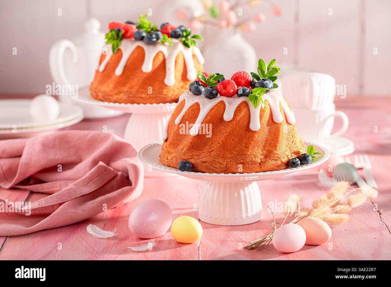 Delicious Easter ring cake on holiday table with decorations. Cake, Easter eggs and flowers for Easter. Stock Photo