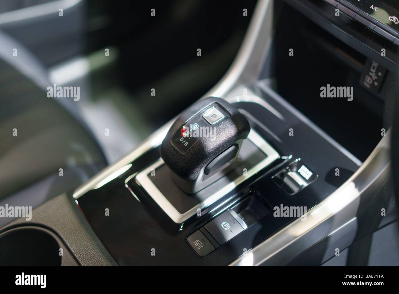 close-up of a contemporary automatic gear shift knob in a glossy car console, highlighting convenience, style, and interior automotive design. Stock Photo
