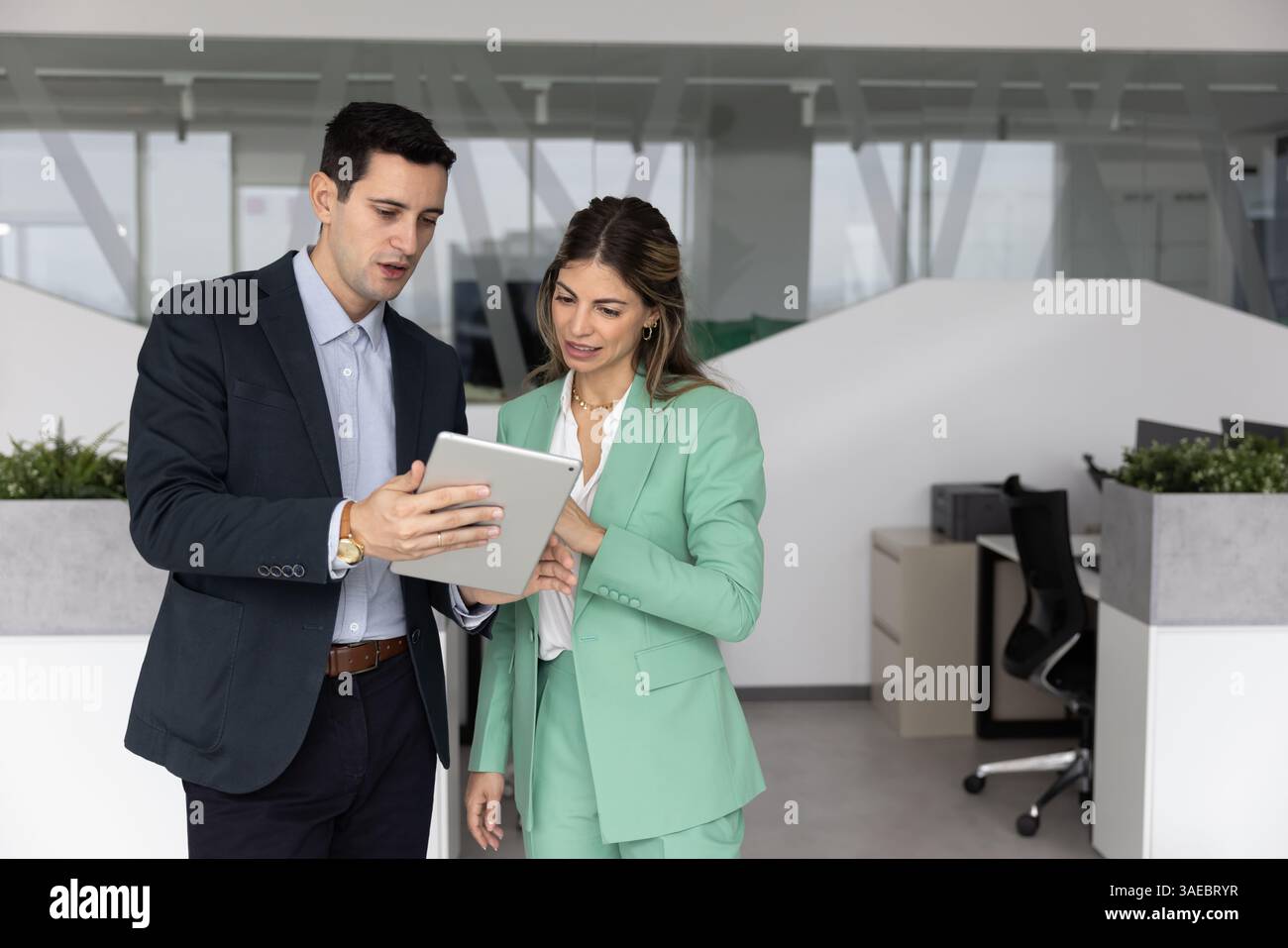 Busy office colleagues using tablet together, working on business plan Stock Photo