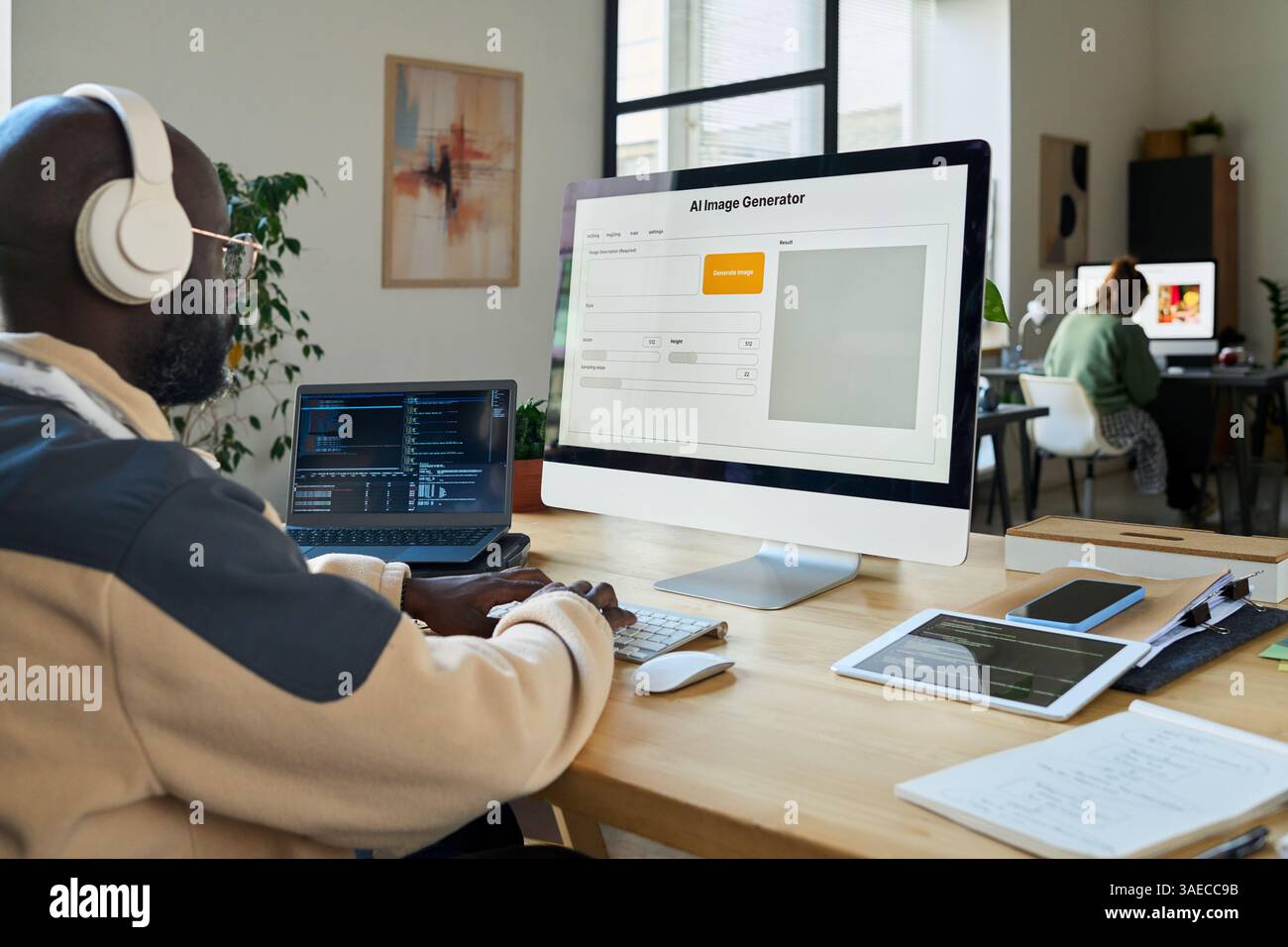 Young African American software developer testing AI image generation program on desktop computer and laptop Stock Photo