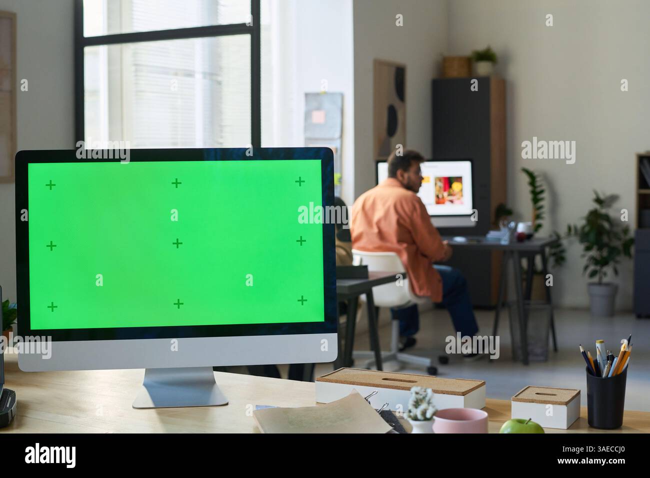 Desktop computer with blank chromakey screen standing on workplace of software developer or programmer in modern office Stock Photo