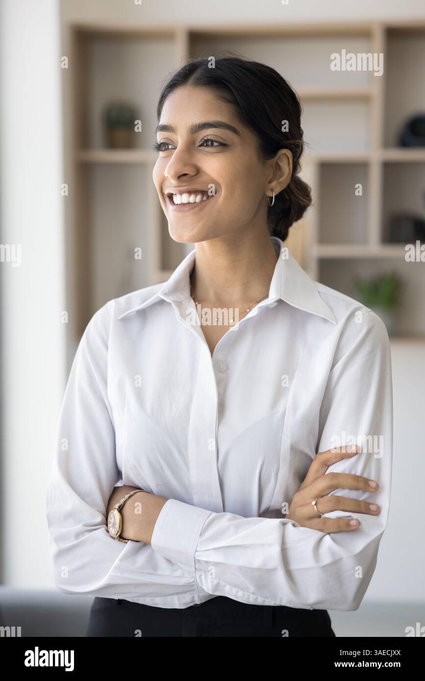 Dreamy successful Indian businesslady smiling looking into distance Stock Photo