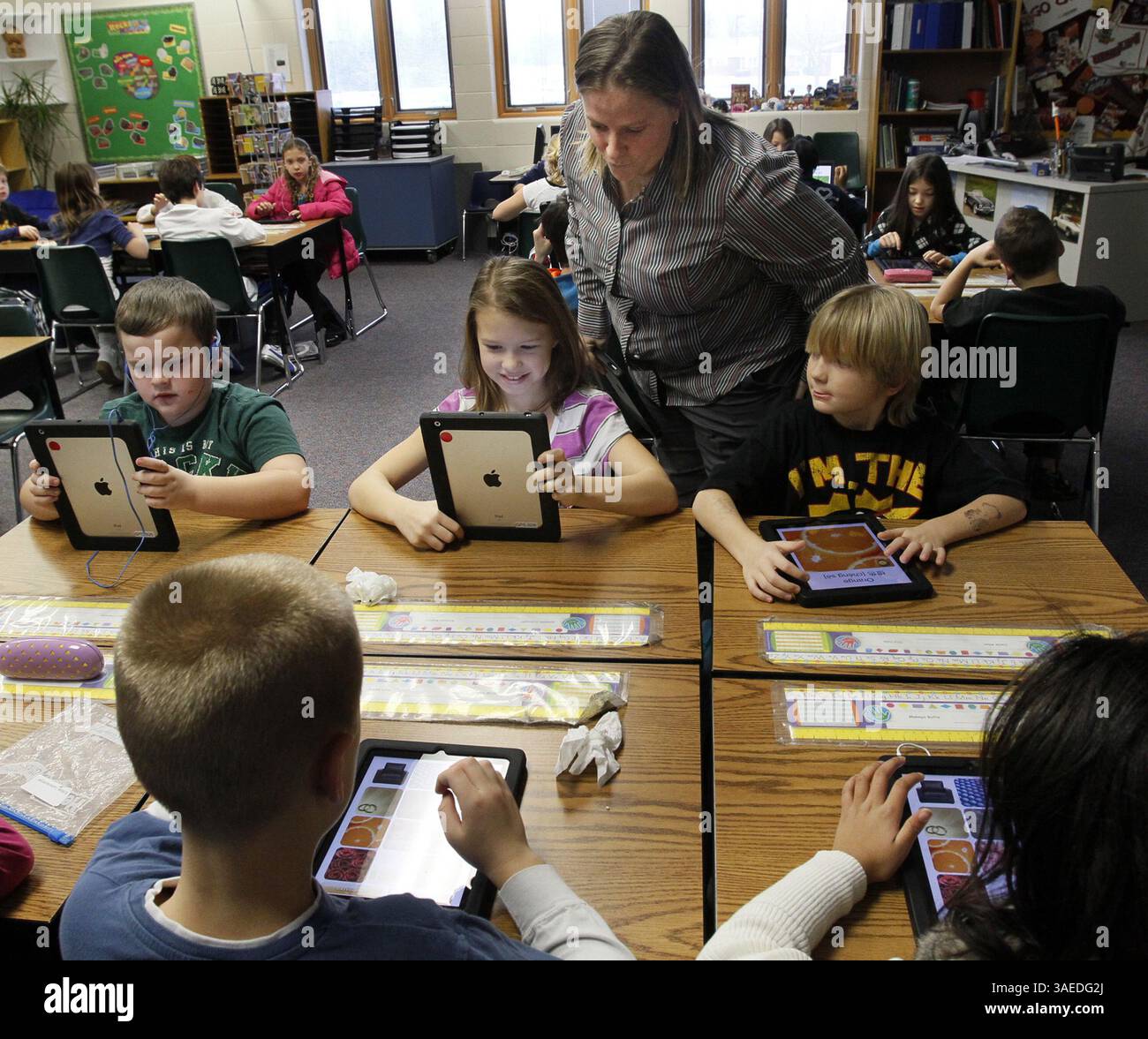 Jan. 5, 2012 - Green, OH, USA - Julie Buckler, iPad teacher, center, instructs students using iPads in J.T. Kuzior's third grade class at Green Primary School in Green, Ohio, on Thursday, January 5, 2012. Local entrepreneur Randy Theken has donated the 90 iPads to the school. (Credit Image: © Paul Tople/Akron Beacon Journal/MCT/ZUMAPRESS.com) Stock Photo