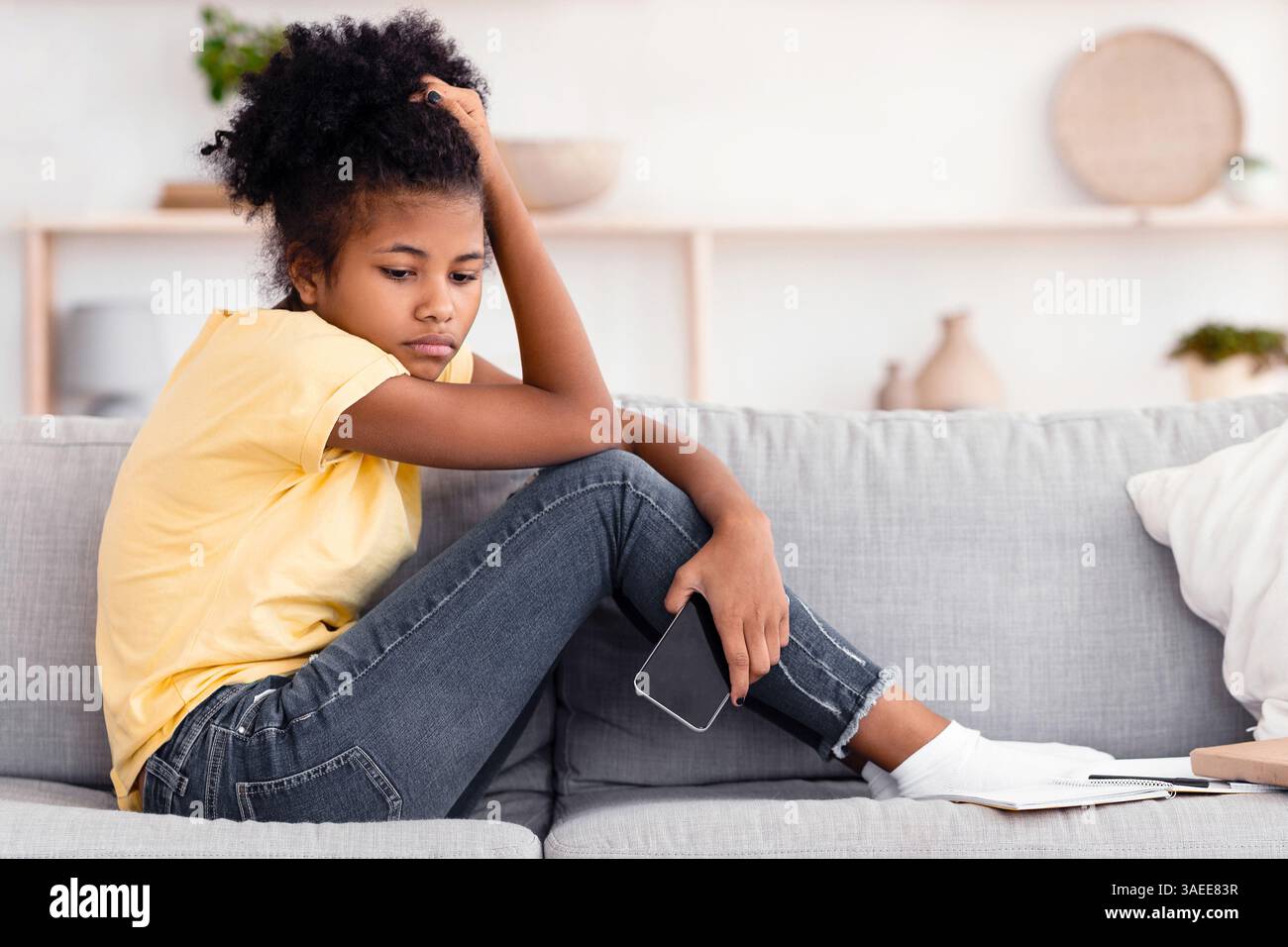 Depressed Teenager Girl Holding Phone Sitting On Couch At Home Stock ...