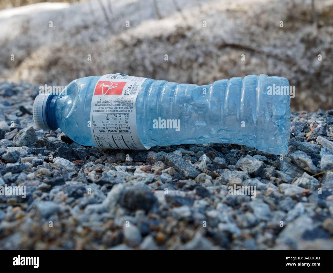 Empty plastic water bottle laying on the ground Stock Photo