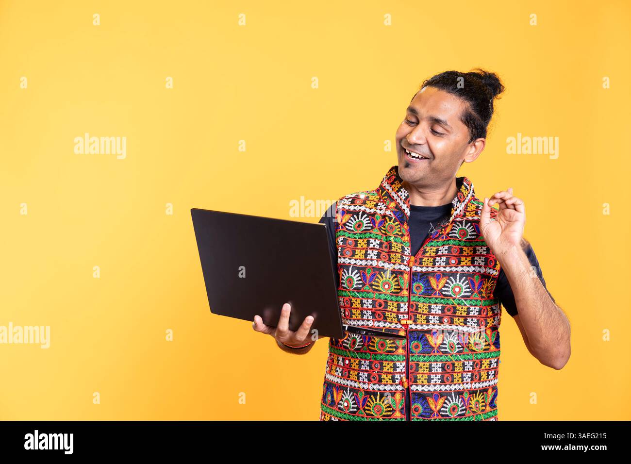 Happy software engineer remotely solving bugs for client over internet videocall on notebook. Cheerful IT technician discussing with customer on online videoconference, studio background Stock Photo