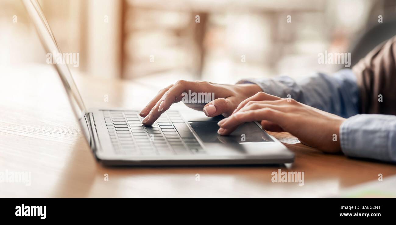 Female hands typing on laptop over blurred background Stock Photo