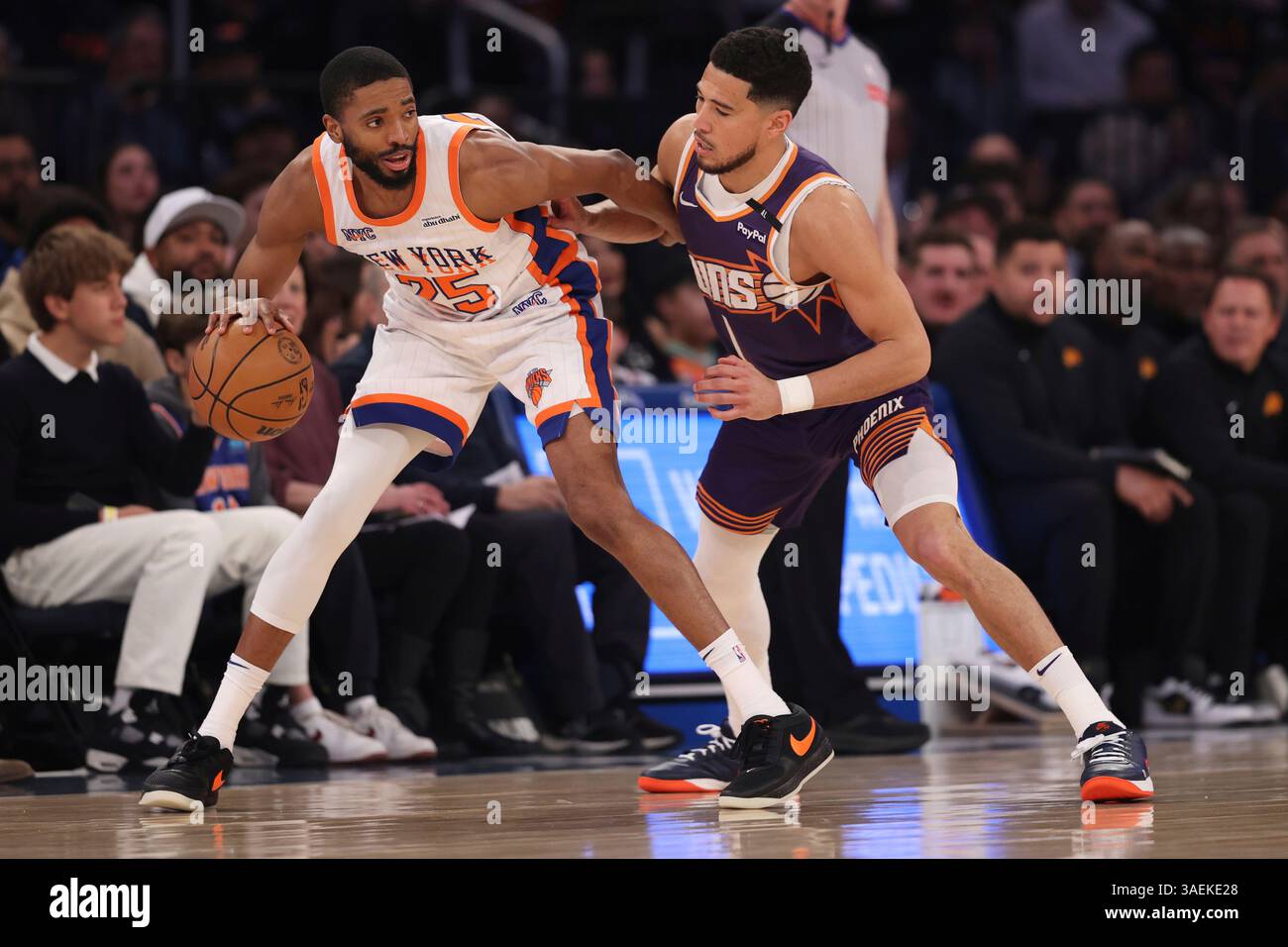 New York Knicks' Mikal Bridges, left, dribbles the ball against Phoenix