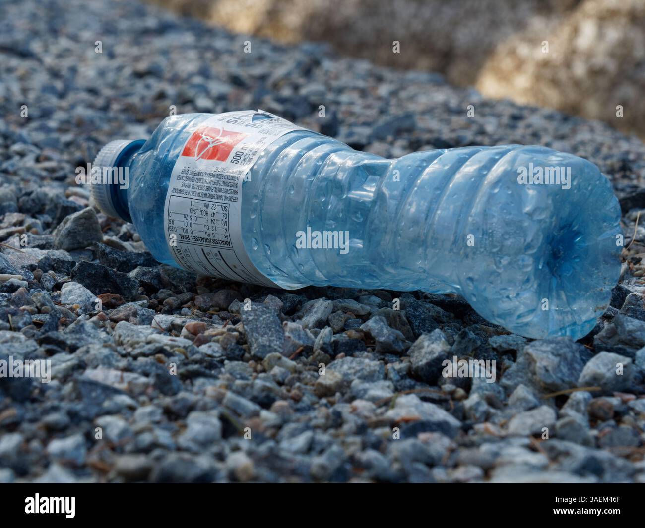 Empty plastic water bottle laying on the ground Stock Photo