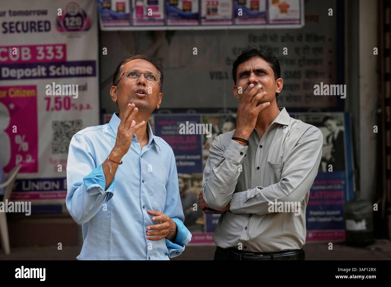 People watch a live screen on the facade of Bombay Stock Exchange (BSE ...