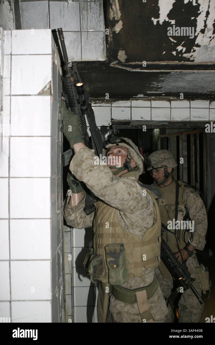 Apr 06, 2005; Fallujah, Iraq; A Marine with Company A, 1st Battalion, 6th Marine Regiment points his rifle up a staircase to provide security for Marines ascending. The unit worked hand-in-hand with Iraqi Security Forces to conduct a cordon and knock operation here and apprehend one suspect while disrupting insurgent planning cell activity. Mandatory Credit: Photo by Cpl. Mike Escobar/DOD/ZUMA Press. (©) Copyright 2005 by US DOD Photo Stock Photo