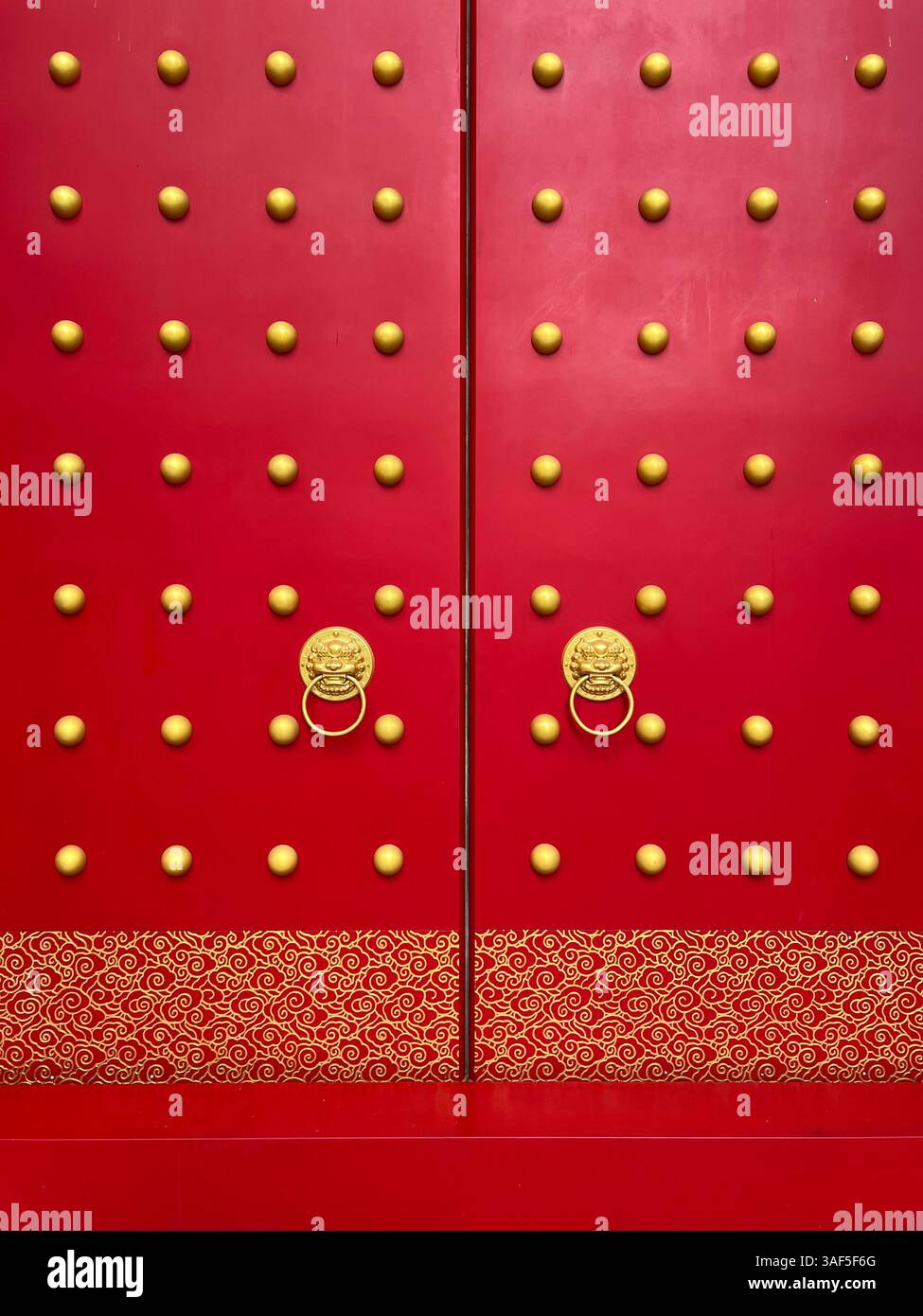 Red door, Chinese style design, temple. Golden lion head door knocker, clean and clear visual oriental auspicious look, vertical view only. Singapore - Smartphone Captured Stock Image