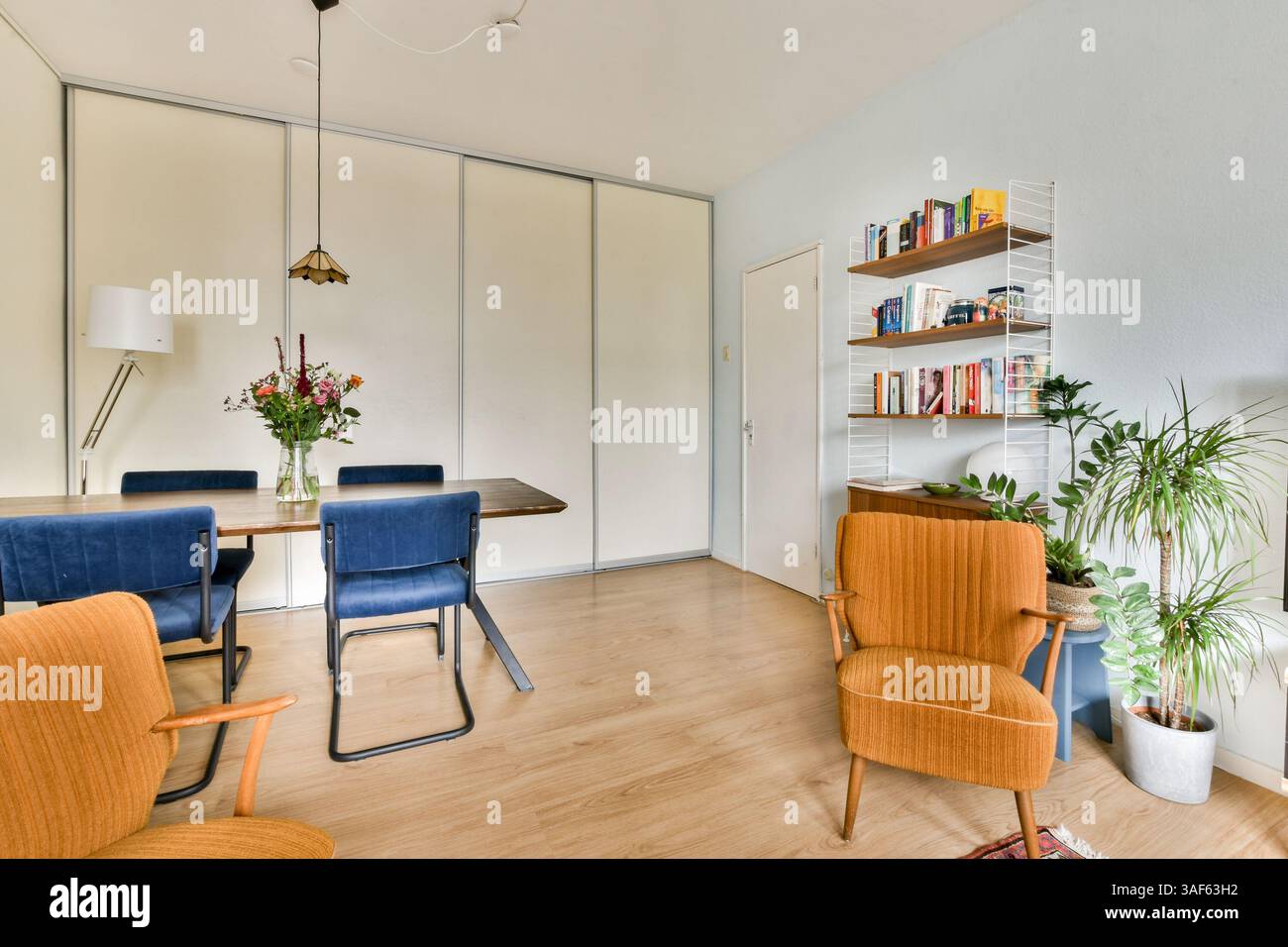 A stylish modern interior featuring a dining area with plants ...
