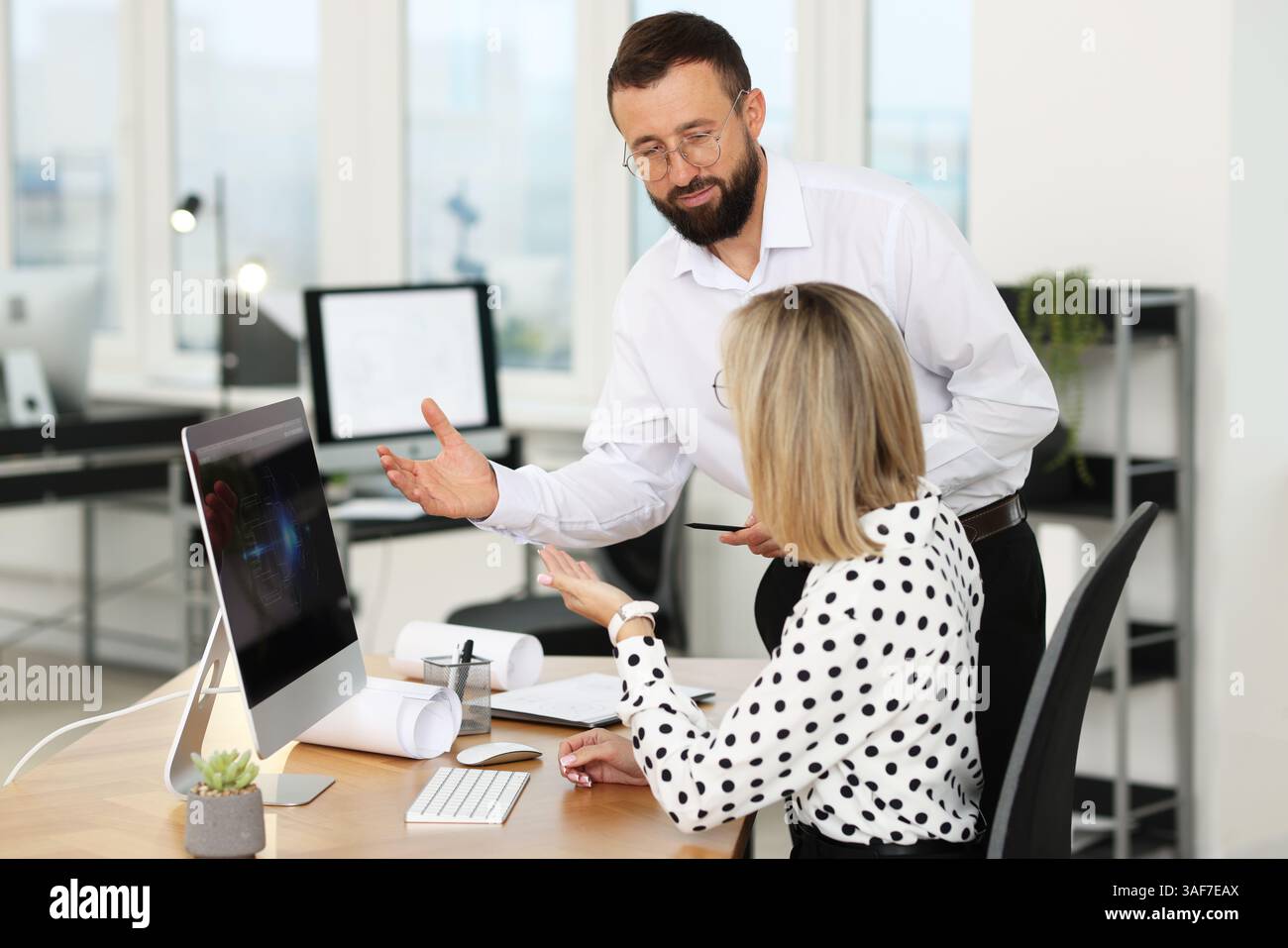 Technicians making digital engineering drawing on computer at desk in office Stock Photo