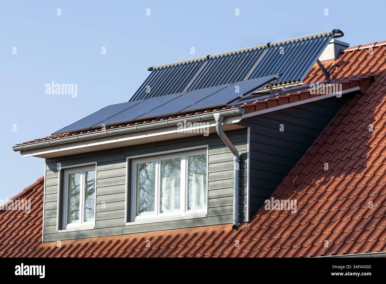 solar modules and vacuum tube collectors on the dormer of a house Stock Photo