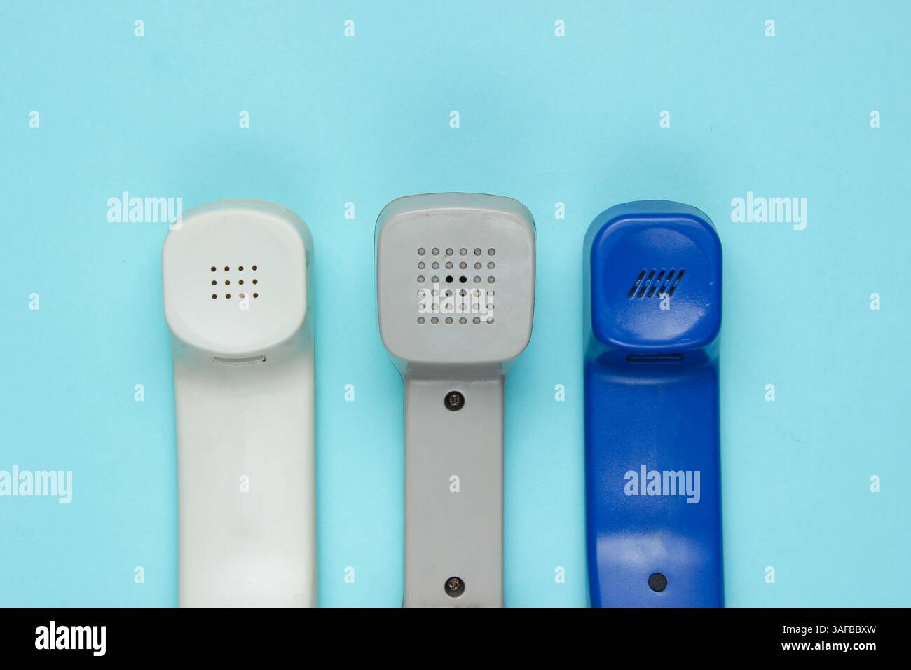 Three retro telephone handsets on blue background. Top view Stock Photo
