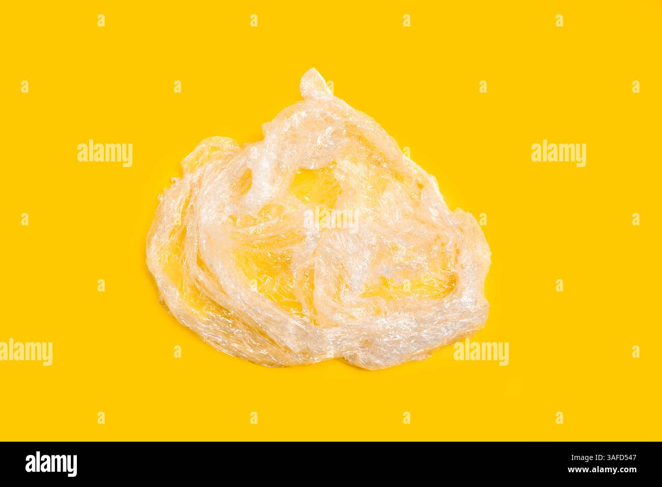 Waste from a plastic wrapper on a yellow background Stock Photo