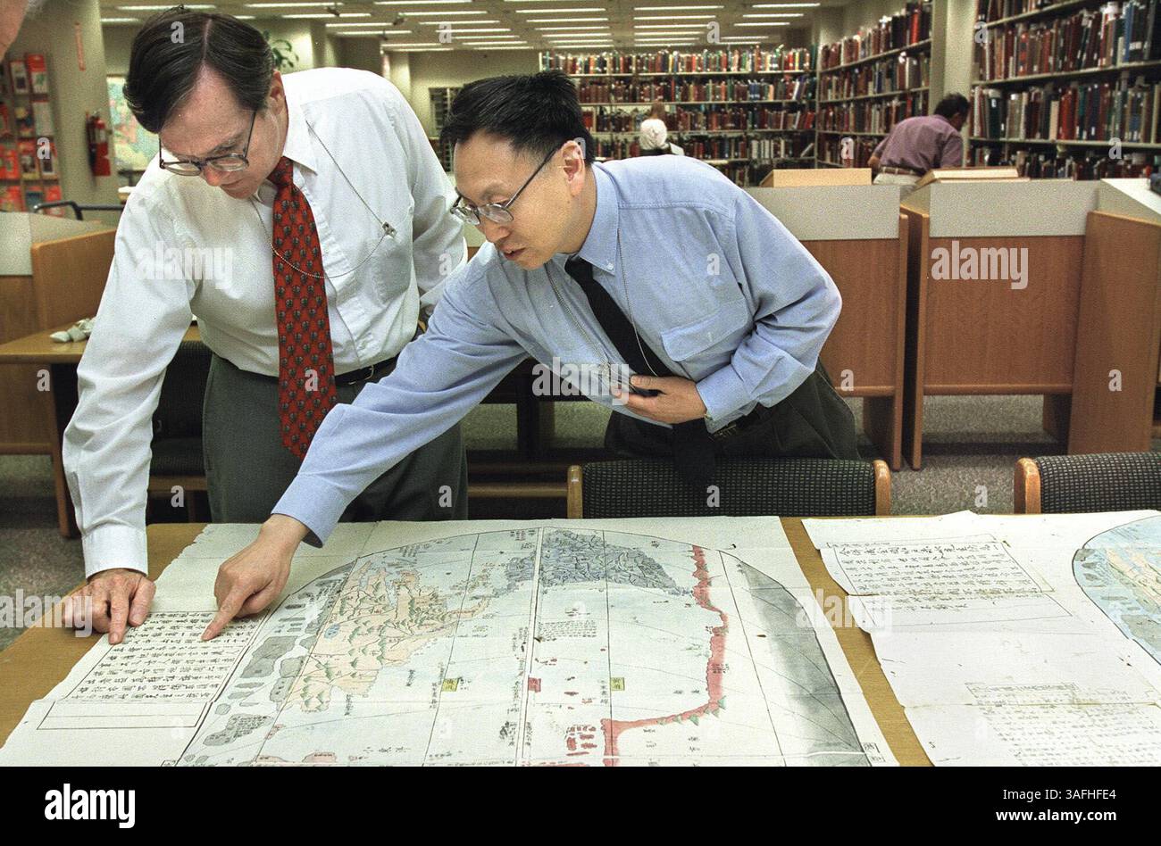 Professor Xiaocong Li, right, from Peking University, confers with ...