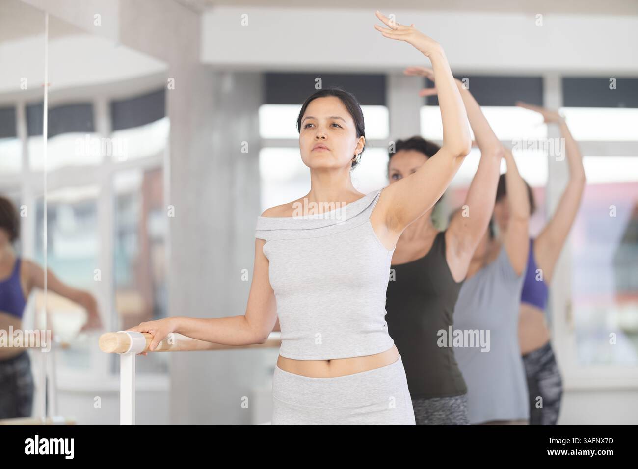 Asian woman practicing third position in amateur ballet class Stock ...