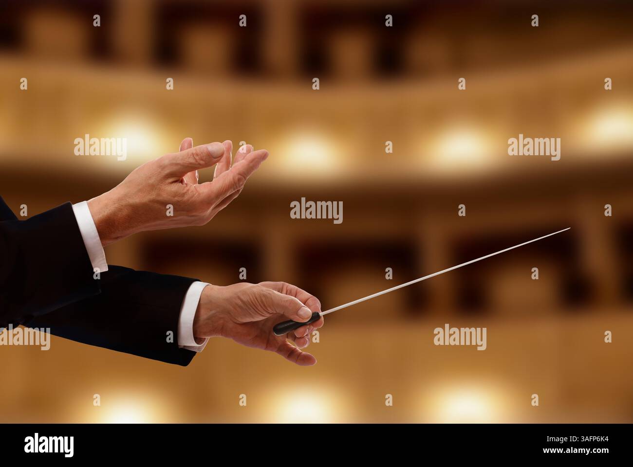 Conductor directing orchestra with baton in concert hall, closeup Stock ...