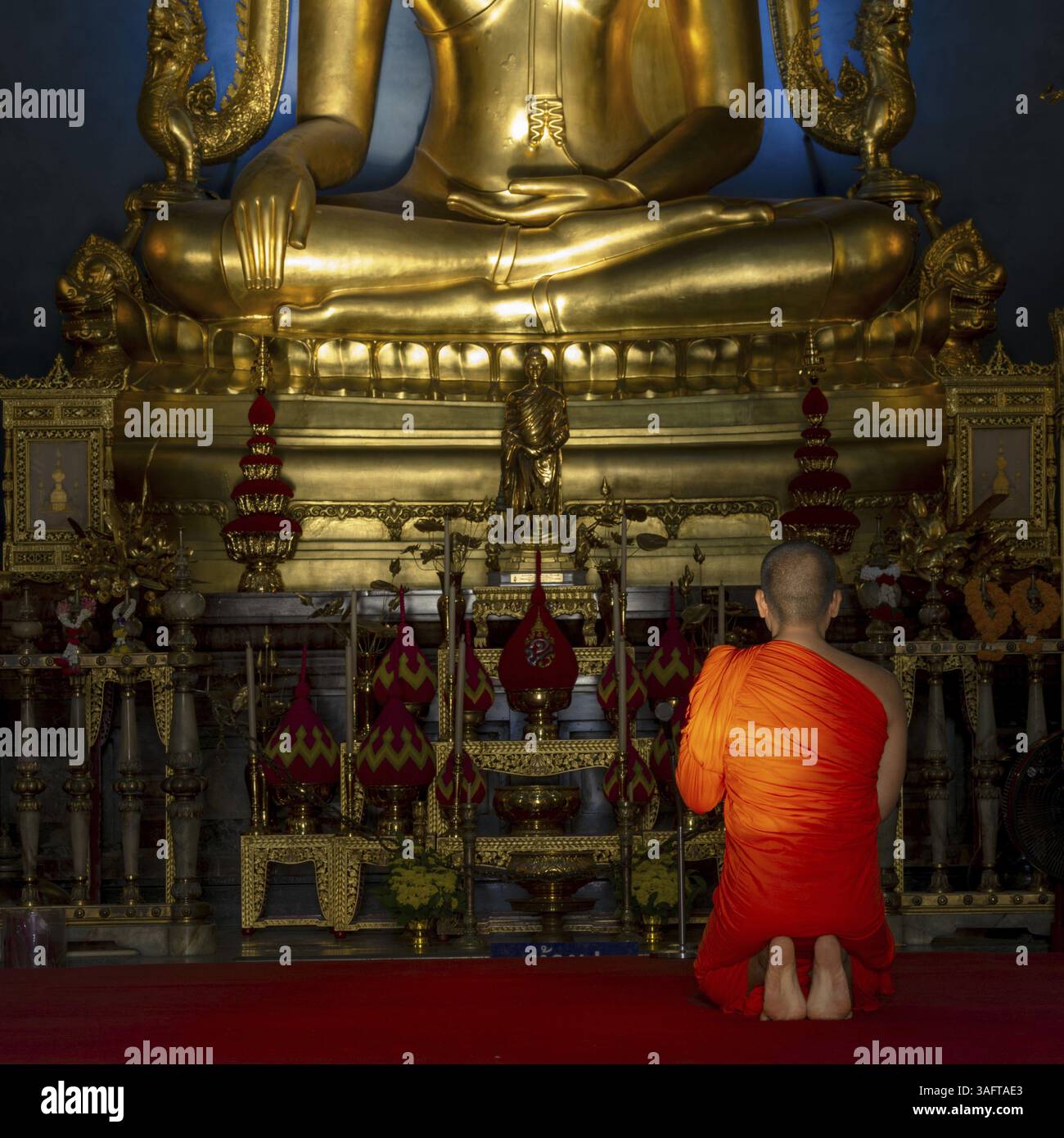 Monk meditating in front of the Phra Buddha Chinnarat, Buddha statue ...