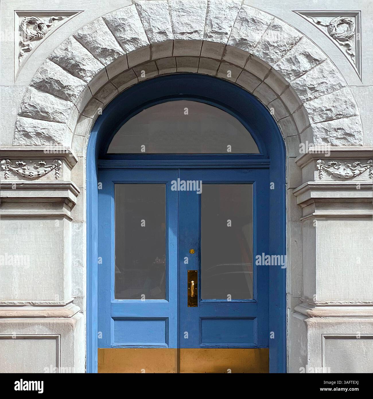 A refined blue double door framed by ornate stonework and a carved archway in Chicago - Smartphone Captured Stock Image