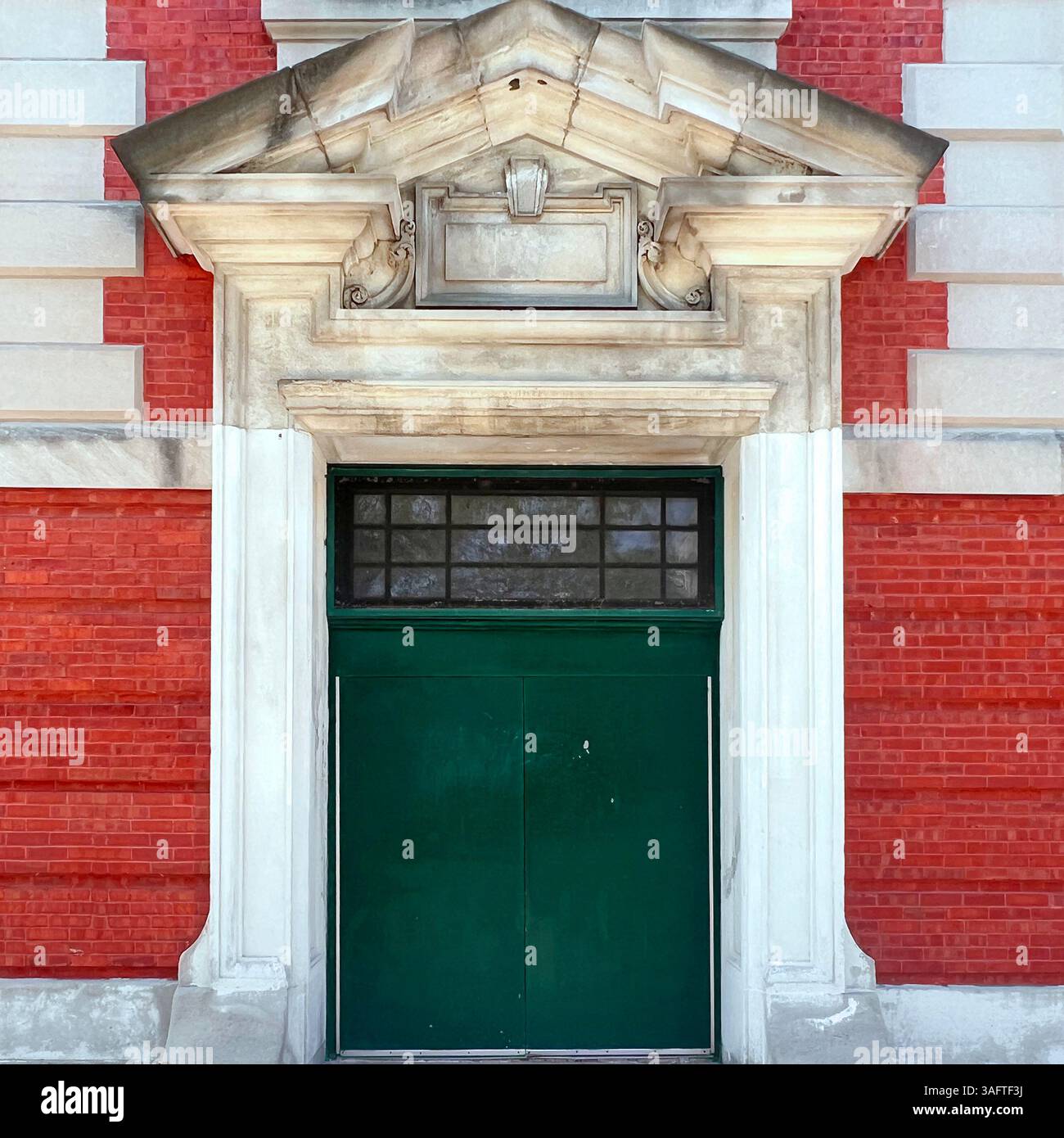 Ornate green doors set in a grand neoclassical stone frame on a historic red brick building in Chicago. - Smartphone Captured Stock Image