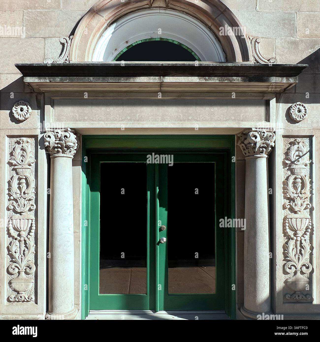 Green doors in a richly ornamented classical stone facade with Corinthian columns, floral carvings, and a half-round transom window in Chicago - Smartphone Captured Stock Image