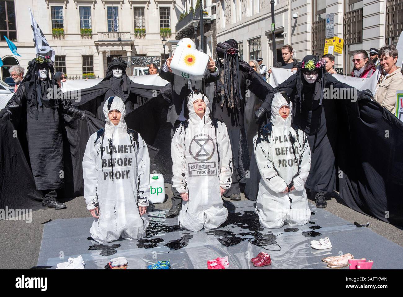 A protester seen pouring oil on the kneeling protesters outside the BP ...