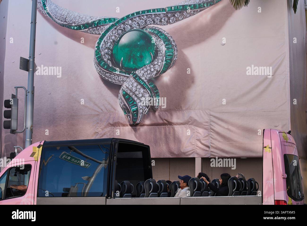 Visitors on a tour bus pass by an advertisement in Rodeo Drive in ...