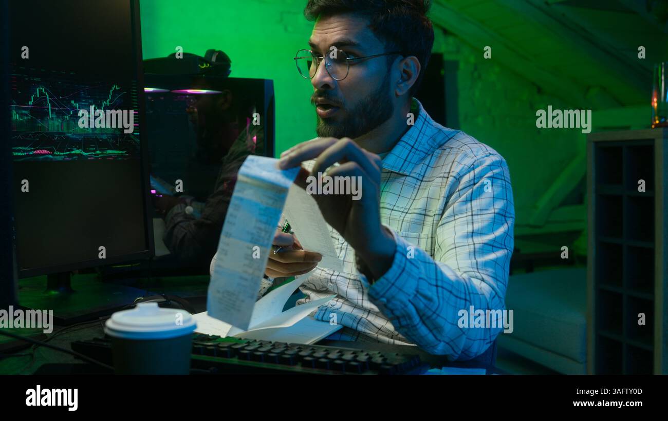 Arabian Indian man male guy programmer examining writing binary code coder freelancer engineer worker IT specialist monitor analyzing computer Stock Photo