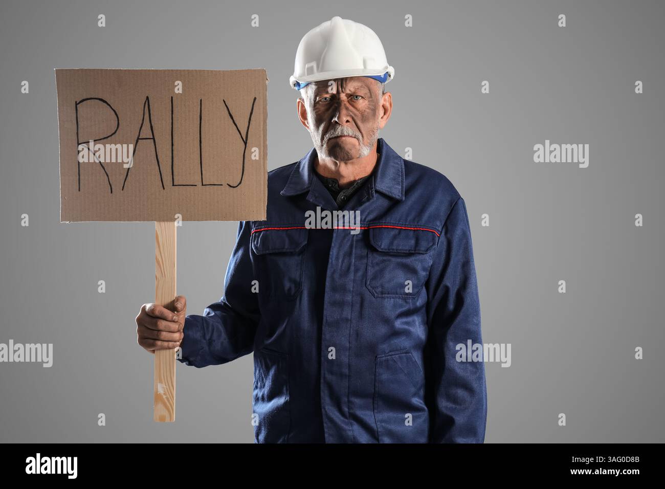 Protesting miner man with placard on grey background Stock Photo