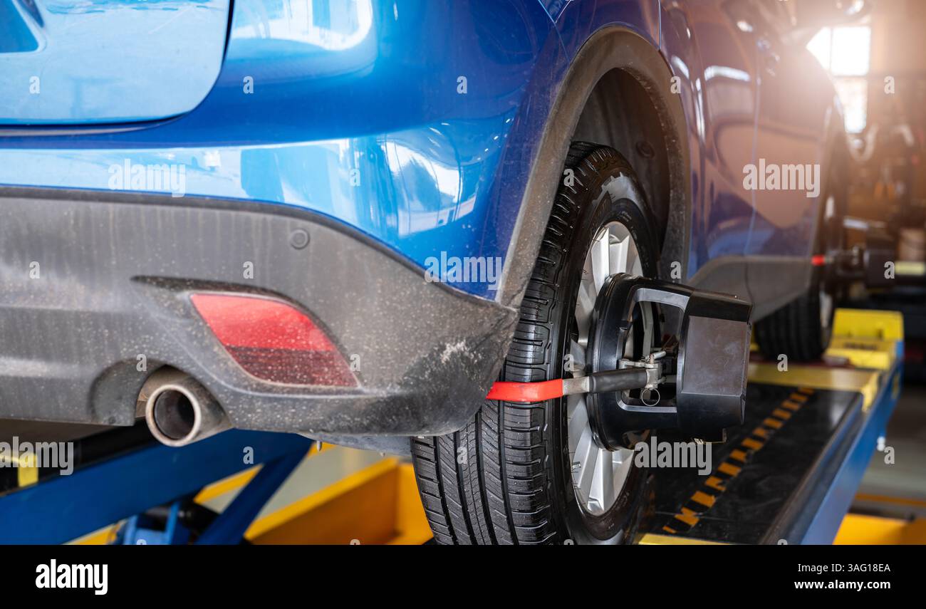 Wheel alignment equipment grip the tire of car wheel in car repair shop ...