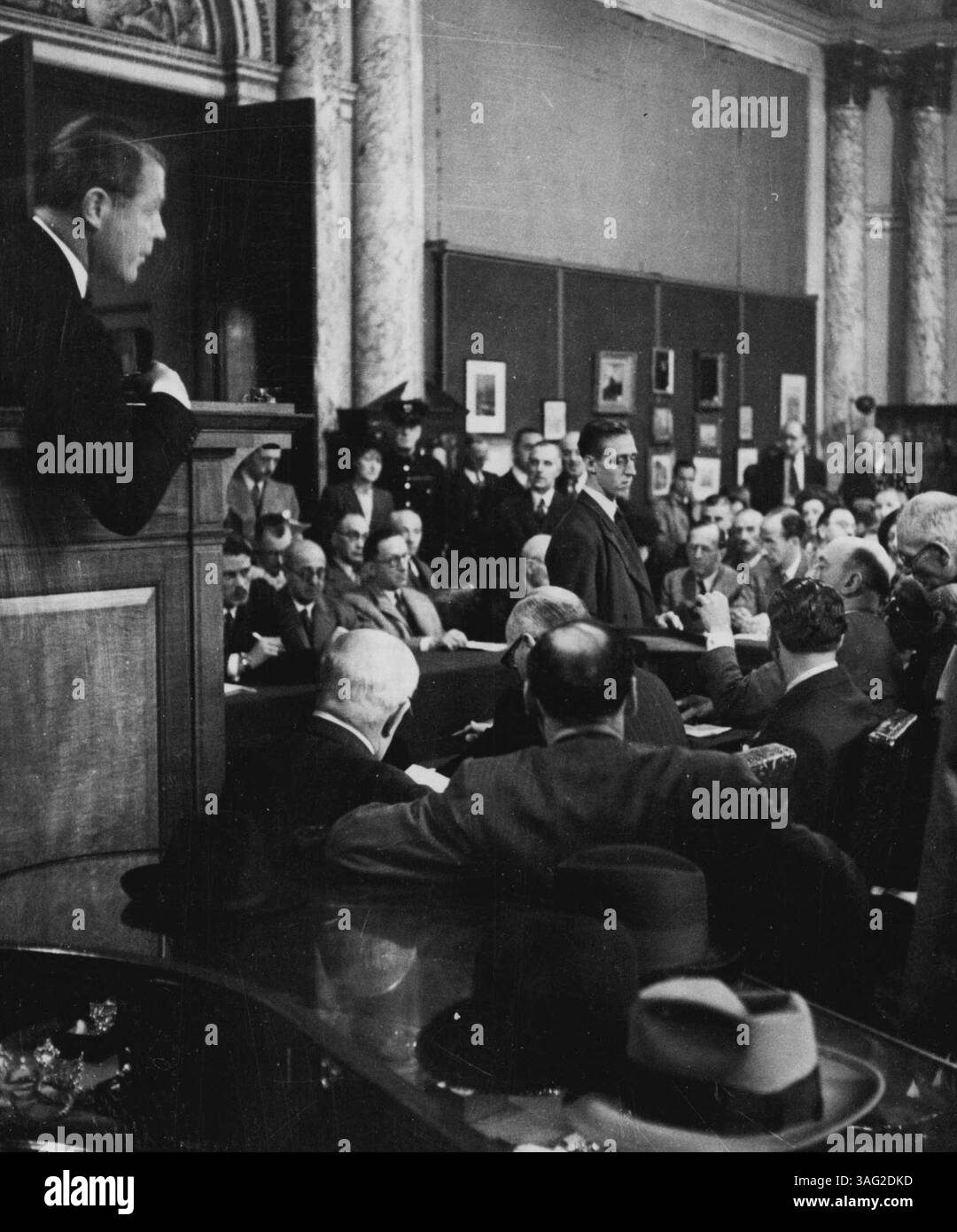 Christie's - Fortunes for Sale - The auctioneer, Mr. Chance, from his box watches the proceedings. The prospective buyers are seated round a horseshoe shaped counter, and an attendant takes round a precious necklace on a tray, to enable the bidders to have another look at the lot to be sold. The sale is conducted with great dignity, there is no shouting here, no noisy outbidding. Indeed it's enough to raise an eyebrow - and the experienced eye of the Auctioneer will notice it. September 12, 1951. (Photo by A. Tanner). Stock Photo