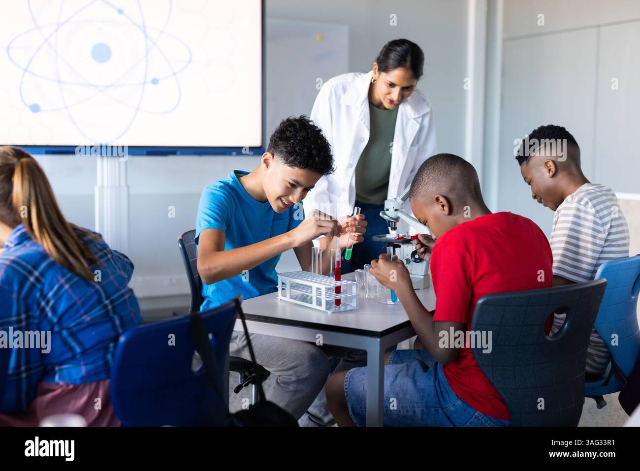 In school, students conducting science experiments with test tubes and microscope Stock Photo