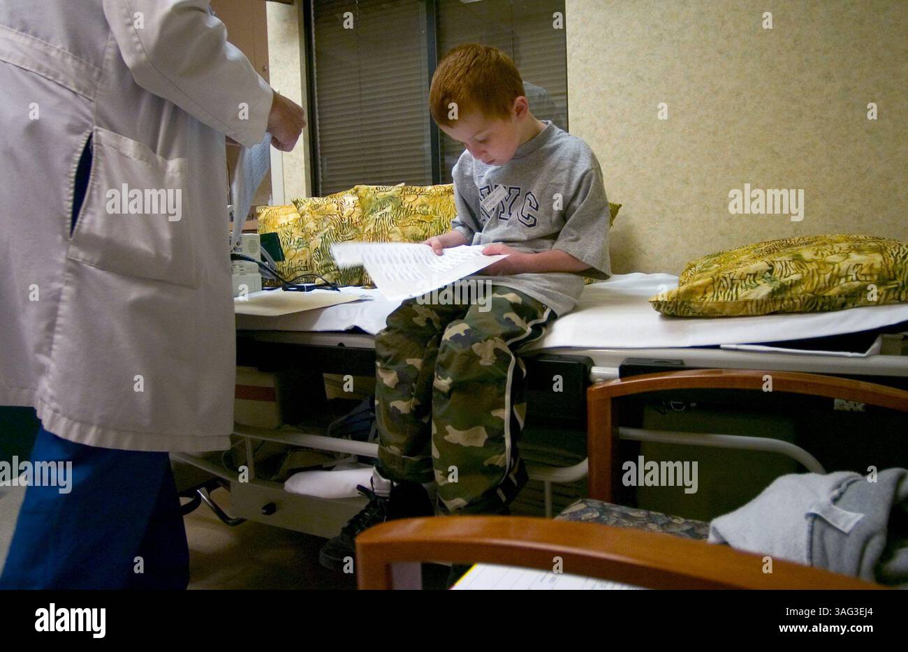 Five-year-old, Anthony Guzman, helps a nurse pull off identification ...