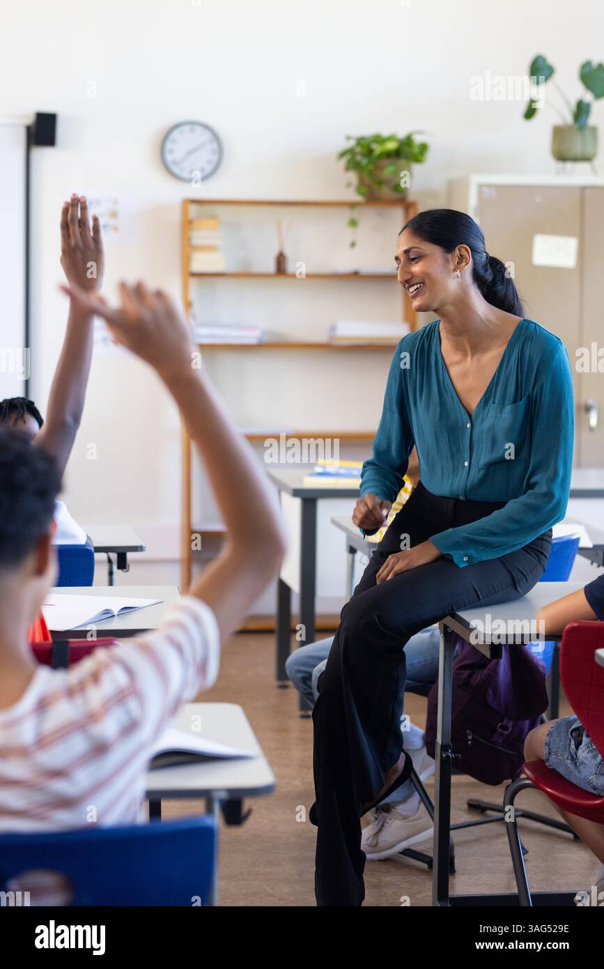 In school, Indian female teacher smiling while engaging with students ...