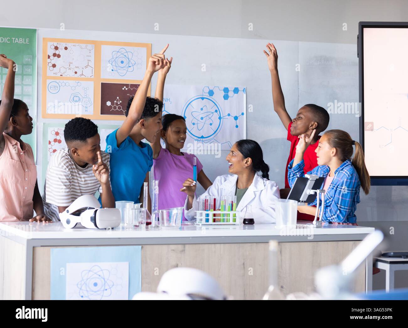 In school, students raising hands and engaging with Indian female ...