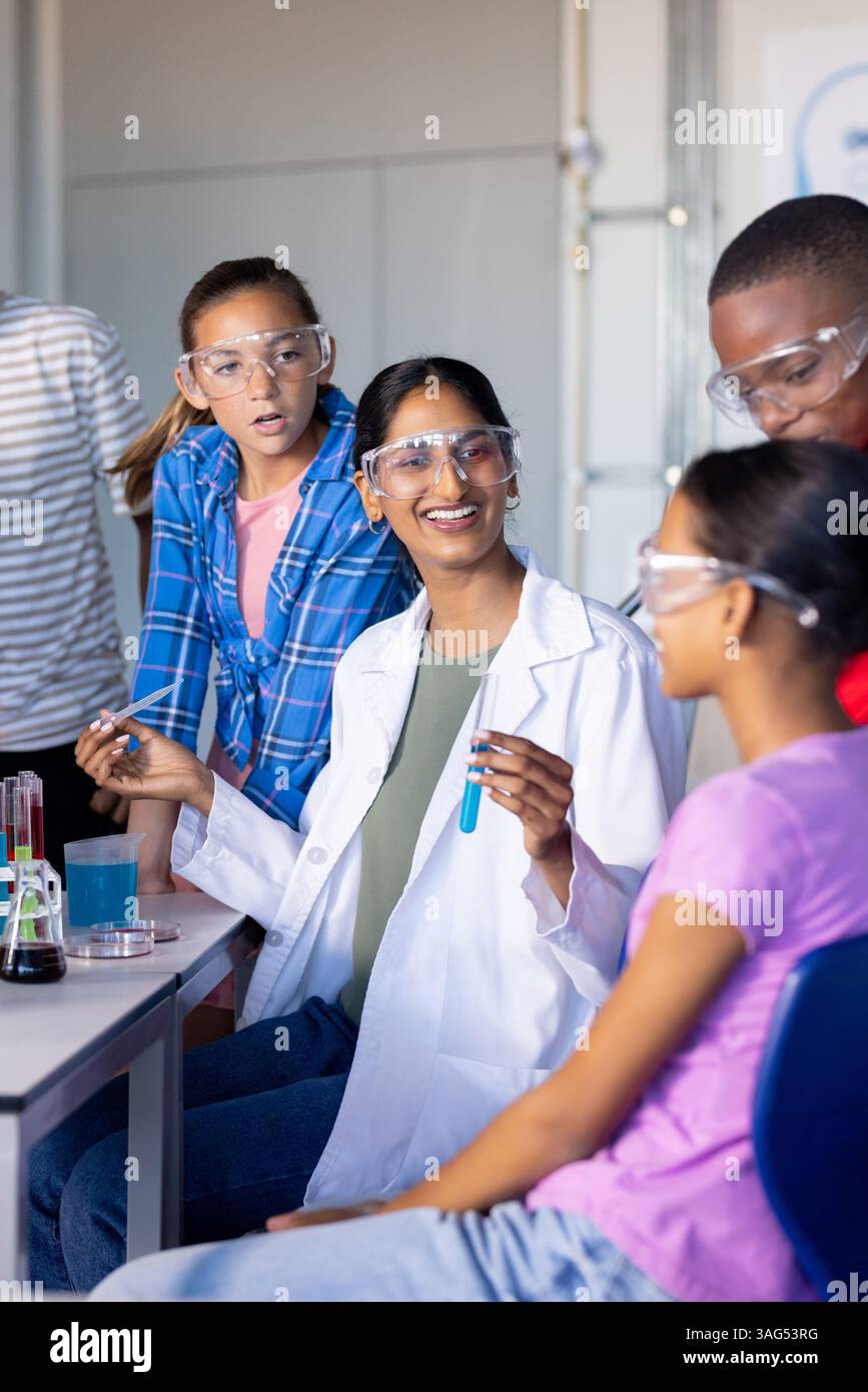 In school, students conducting science experiment with test tubes and safety goggles Stock Photo