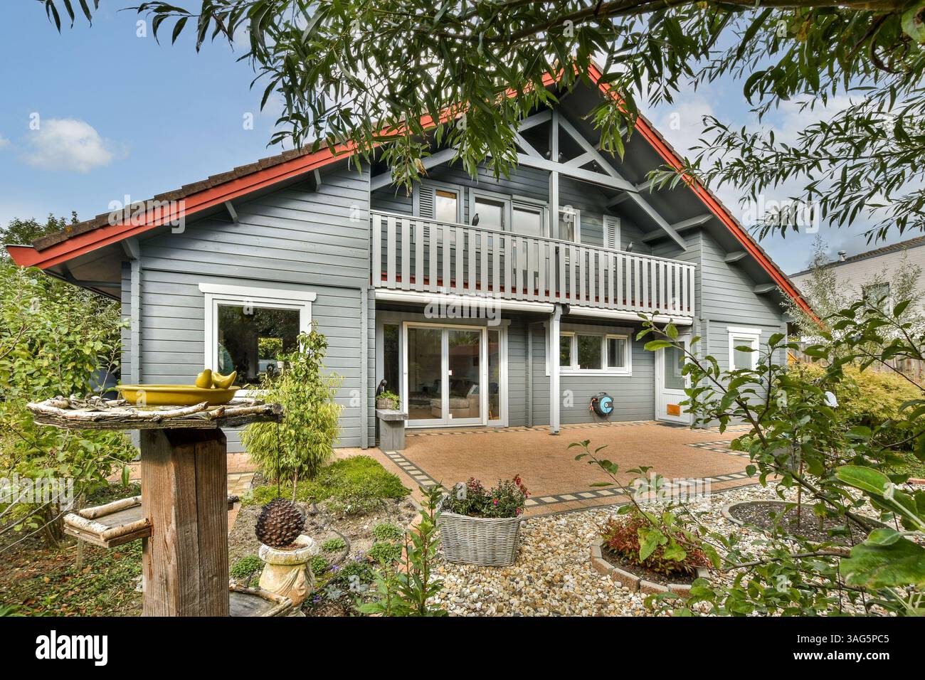 This modern house features a unique design with a red roof and a ...