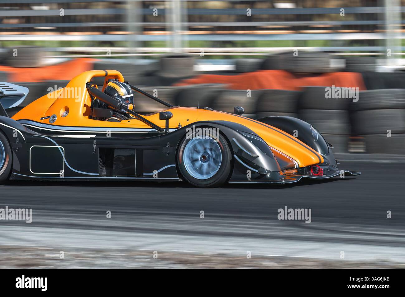 Racing orange-black formula car cornering at high velocity, capturing ...