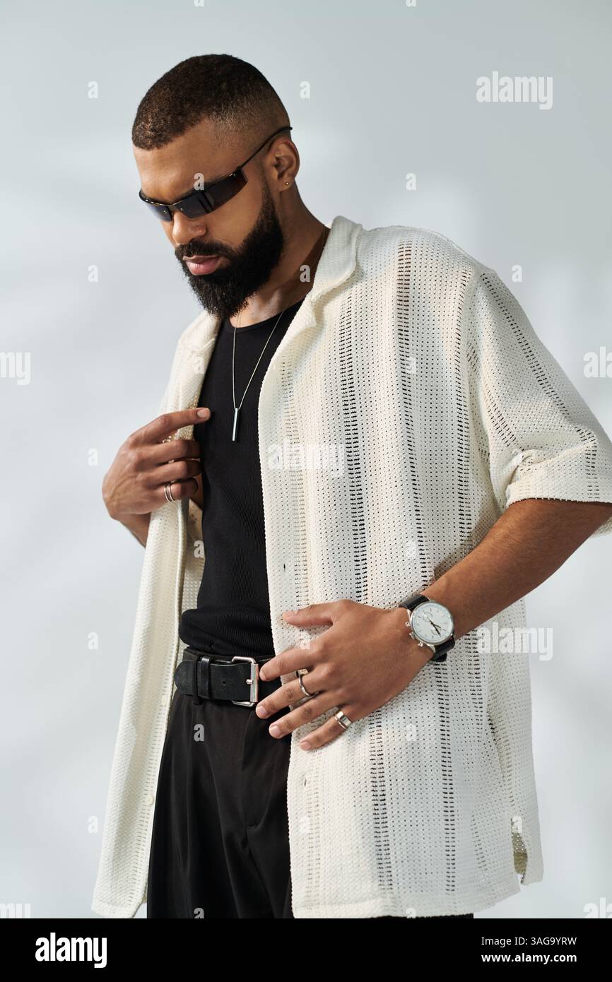 A stylish young man poses confidently in modern attire and accessories ...