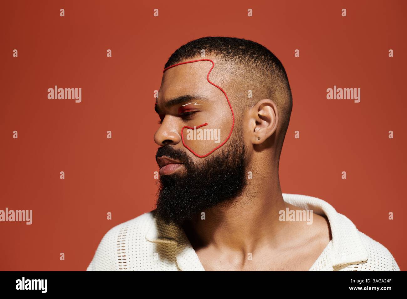 A stylish young man poses confidently with artistic red outlines ...