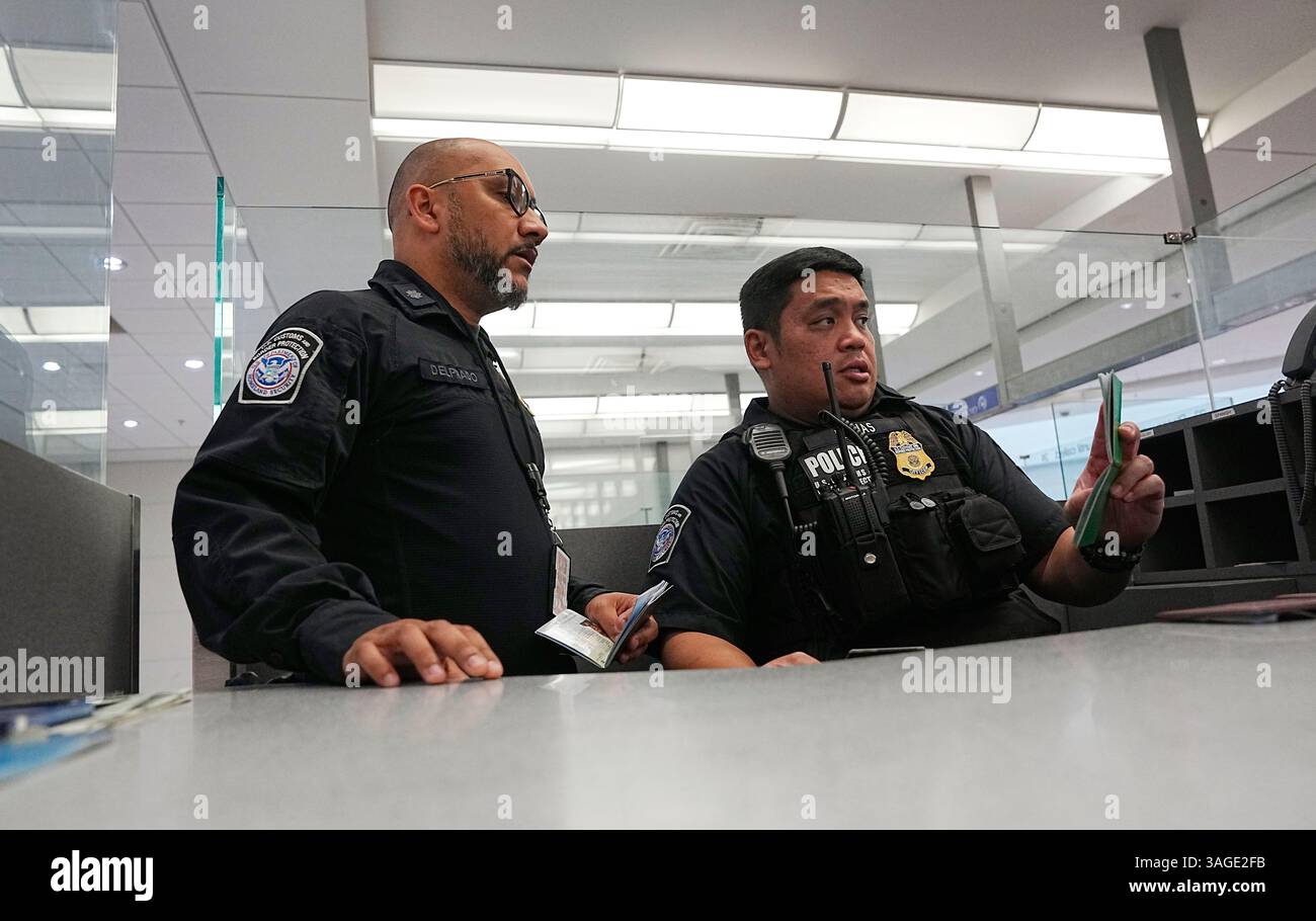 U.S. Customs and Border Protection officers process travelers arriving ...