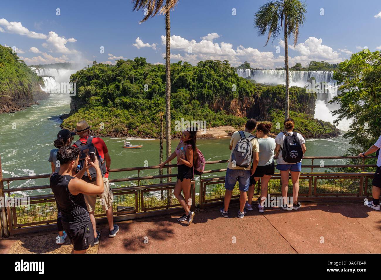 Puerto Iguazu, Misiones, Argentina - April 5th, 2025: Tourists watching Iguazu Falls from the lower circuit in Argentina. Stock Photo
