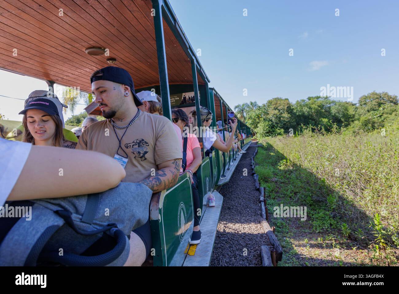 Puerto Iguazu, Misiones, Argentina - April 5th, 2025: Tourists traveling on the Iguazu National Park train. Stock Photo